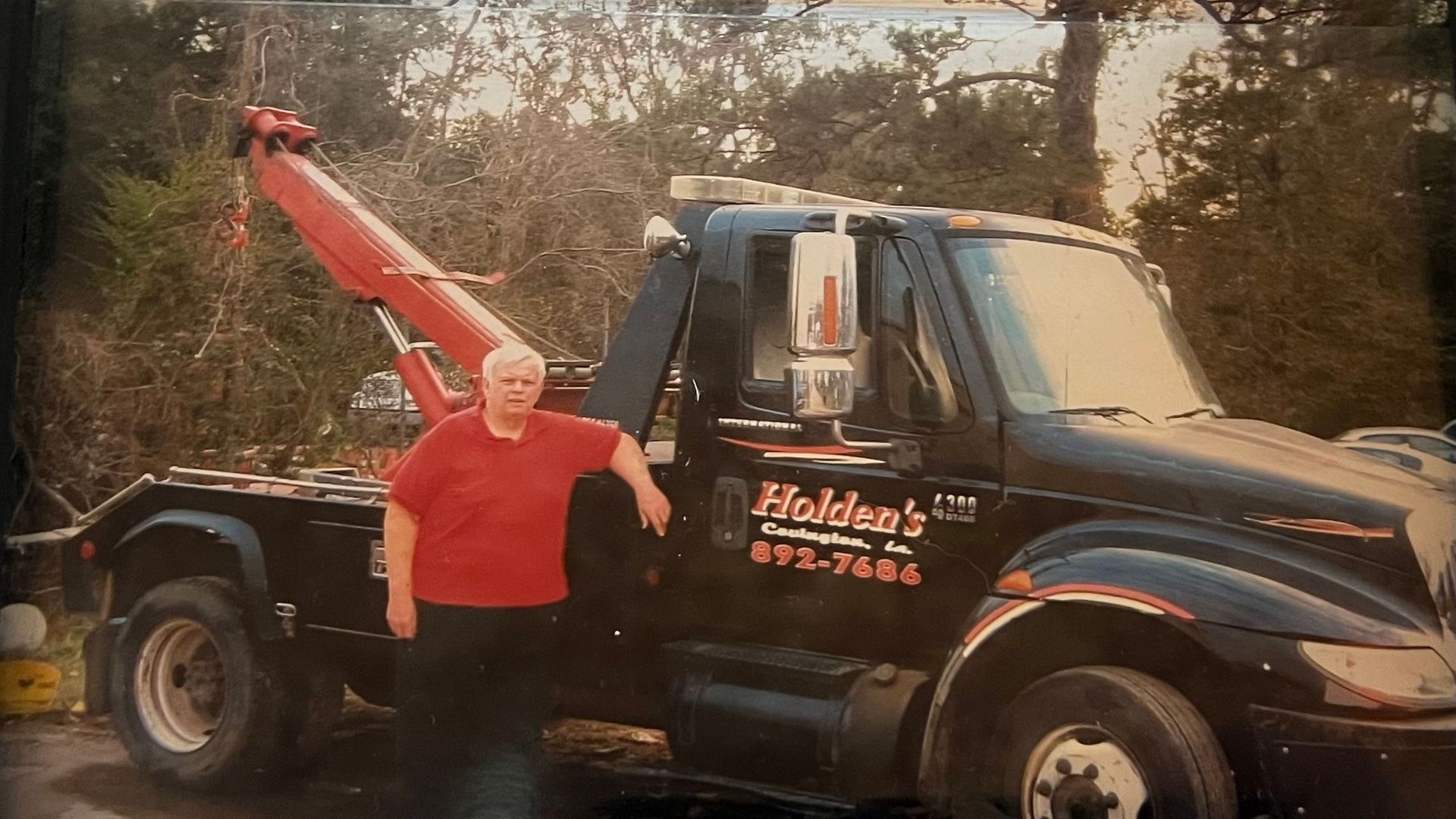 Holden's Wrecker Service owner in front of truck