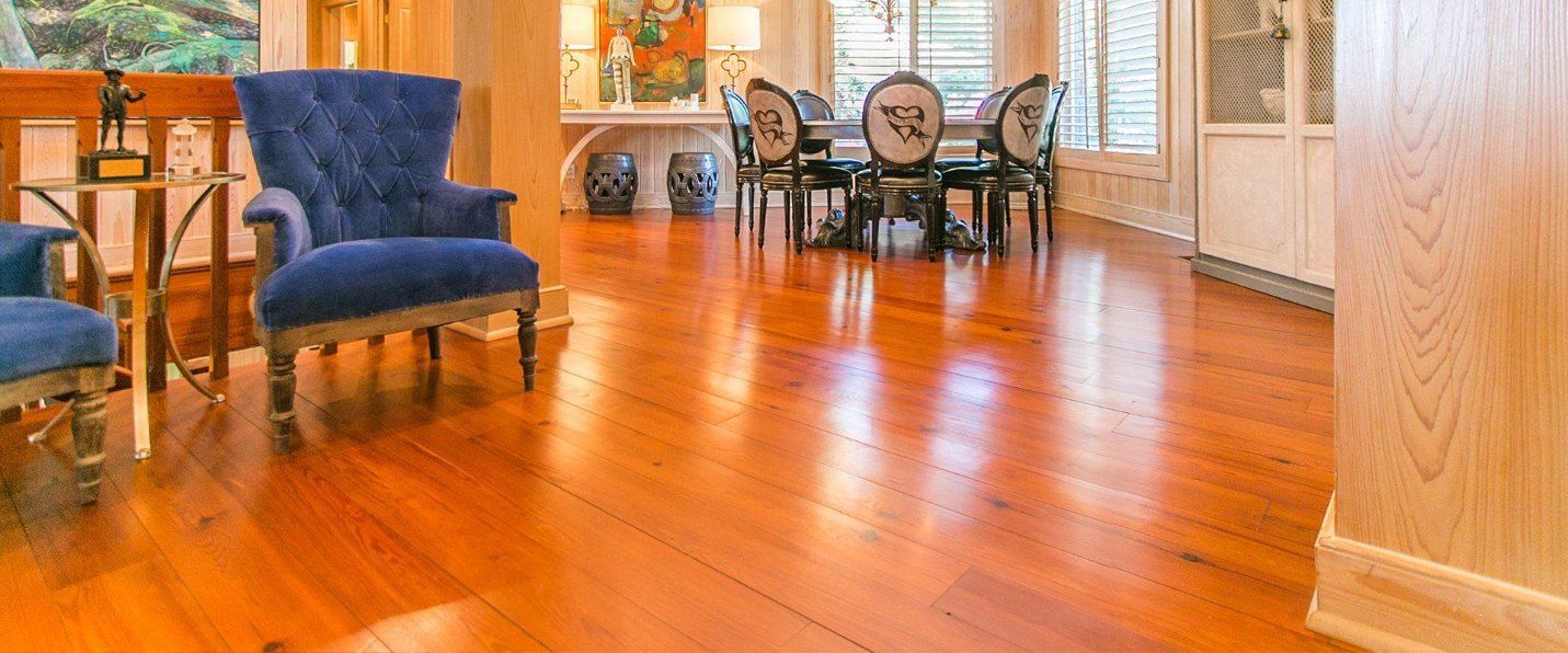 A Living Room With Hardwood Floors and a Dining Room Table and Chairs — Marshall Notaras Hardwoods Pty Ltd In Sydney, NSW