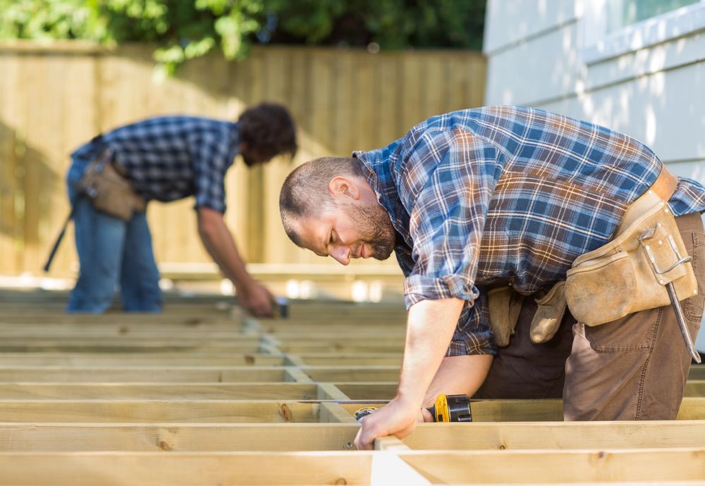 A Wooden Floor is Being Installed By Two Workers — Marshall Notaras Hardwoods Pty Ltd In Armidale, NSW