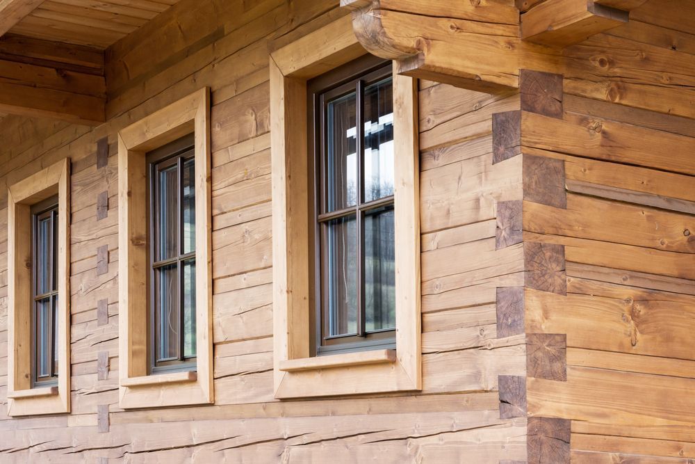 A Wooden House With Three Windows on the Side of It — Marshall Notaras Hardwoods Pty Ltd In Byron Bay, NSW