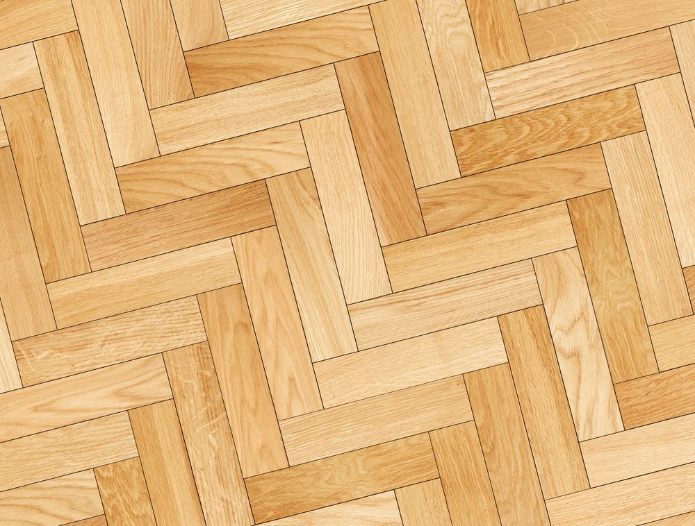 A Close Up of a Wooden Floor With a Herringbone Pattern — Marshall Notaras Hardwoods Pty Ltd In Grafton, NSW