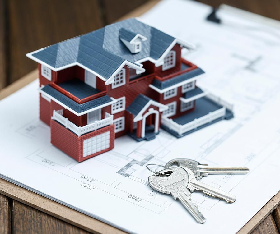 A model house and keys are on a clipboard.