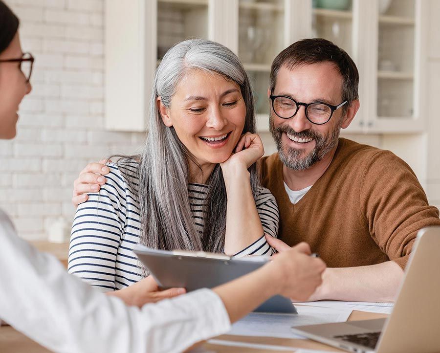 A man and a woman are sitting at a table with a laptop and a tablet.