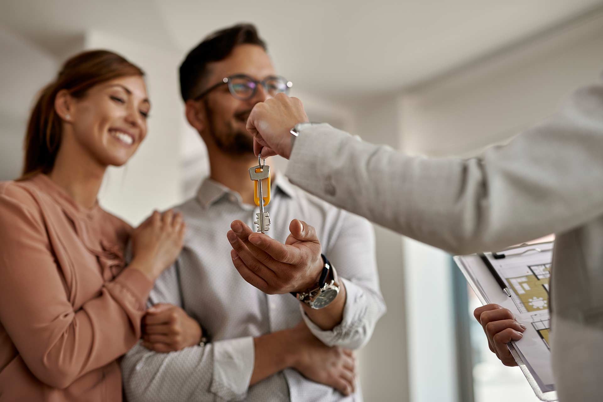 A man is giving a couple of keys to their new home.