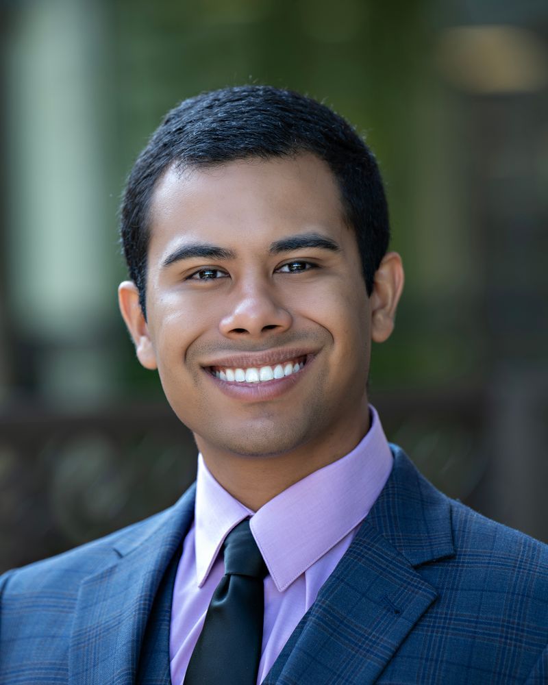 A man in a suit and tie is smiling for the camera.