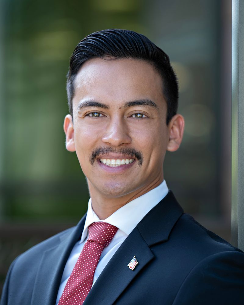 A man in a suit and tie is smiling for the camera.