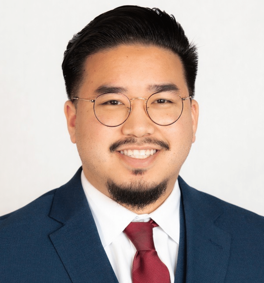 A man in a suit and tie is smiling for the camera.