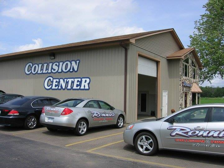 Collision center building with parked cars and open garage bay