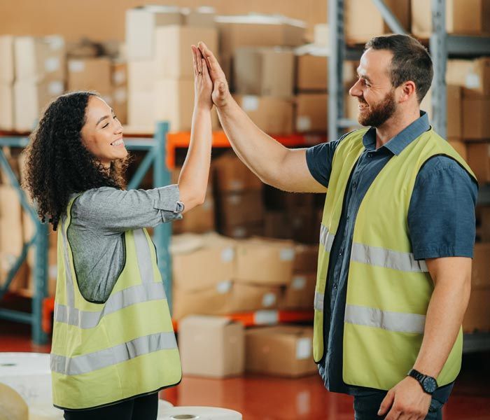 warehouse workers high fiving
