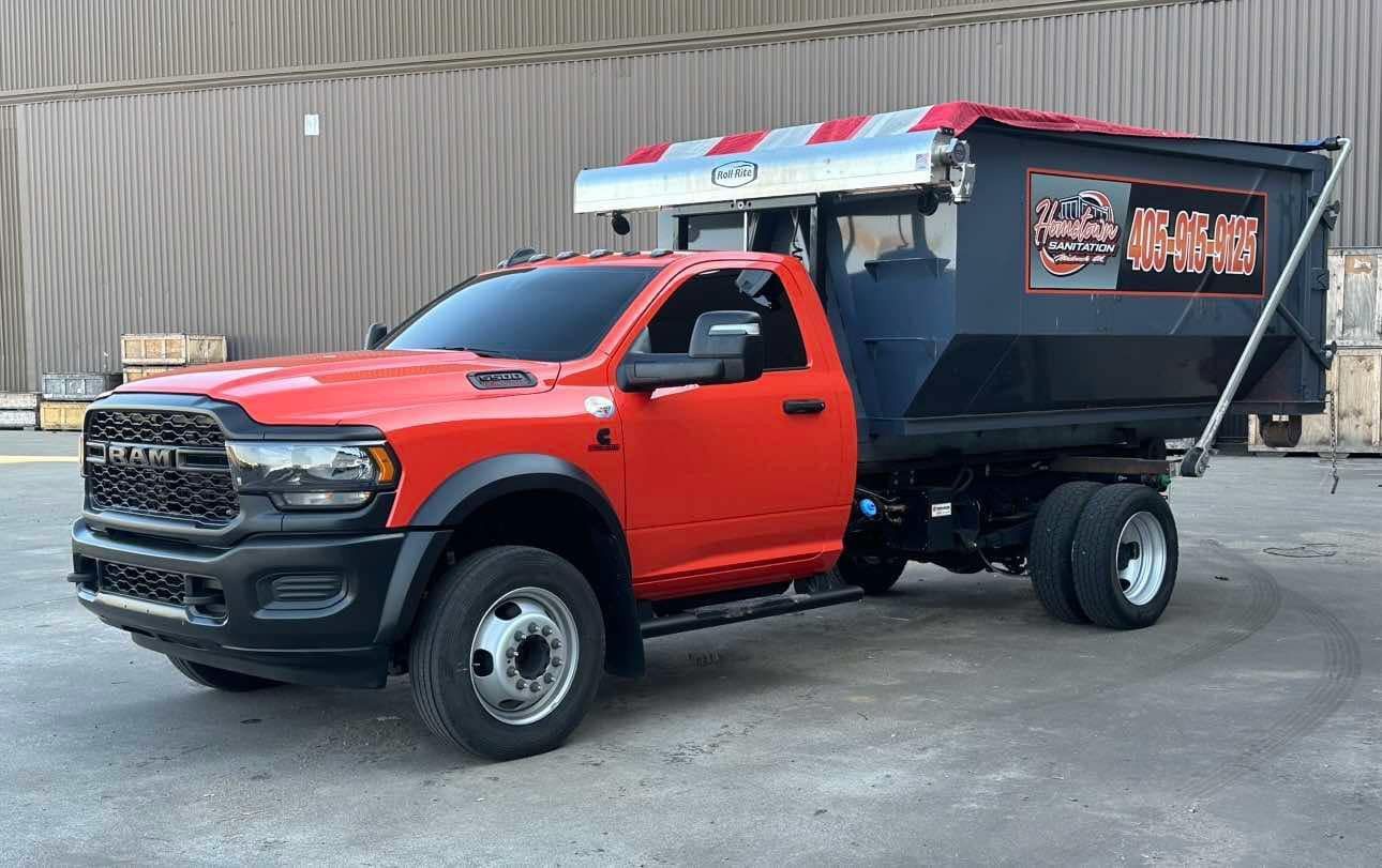 A red dump truck is parked in front of a building.
