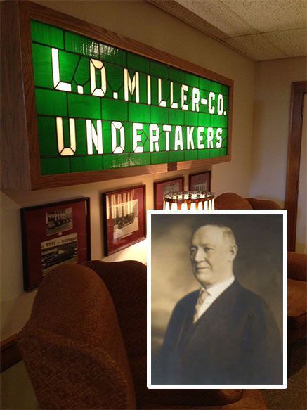 L.D. Miller Co. Undertakers sign above framed portrait in a dimly lit memorial display room