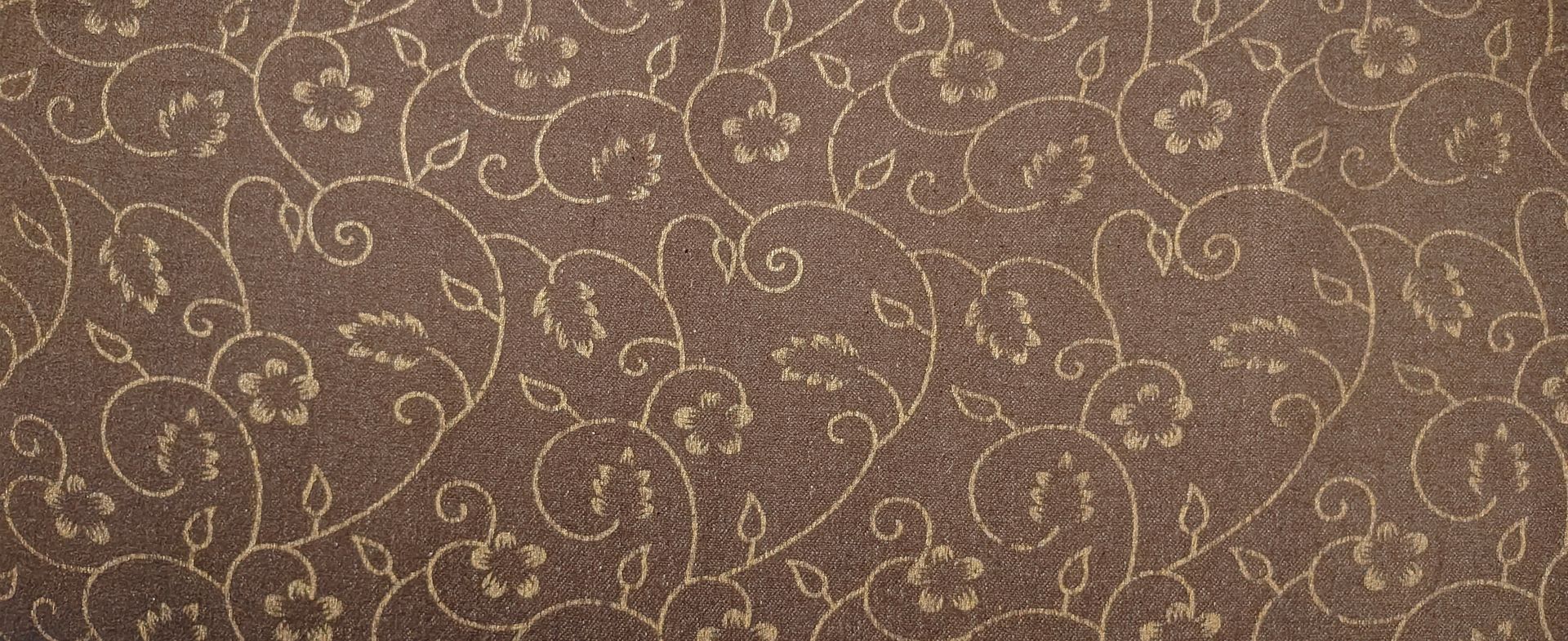 Brown patterned fabric with a gold swirling floral design