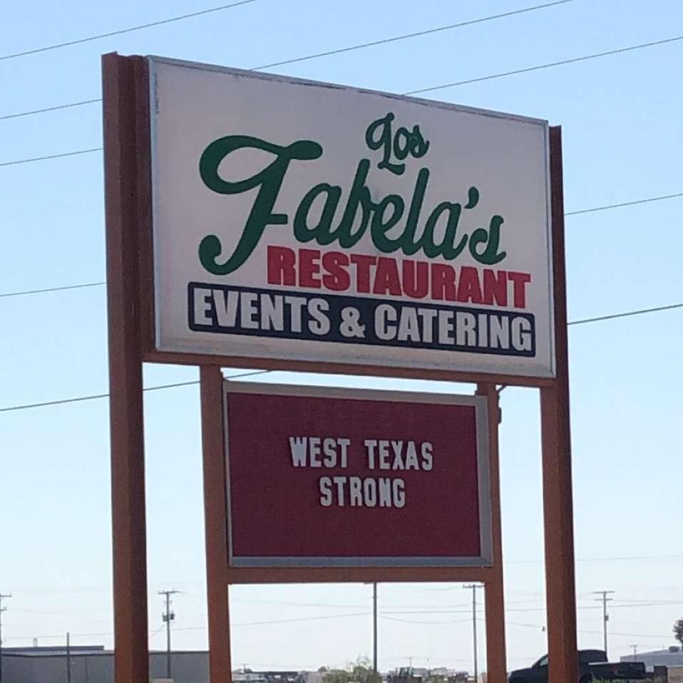 A Los Fabela's restaurant sign under a blue sky, with a marquee below reading 