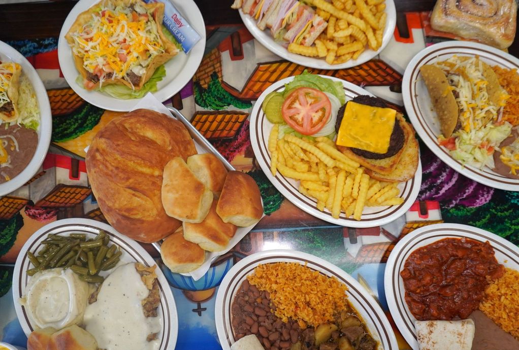 A buffet serving line featuring rows of hotel pans filled with various prepared foods, including breaded meat and sides.