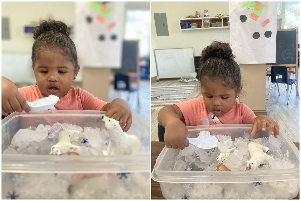 Child playing with ice in a clear bin at a classroom table, focusing intently.