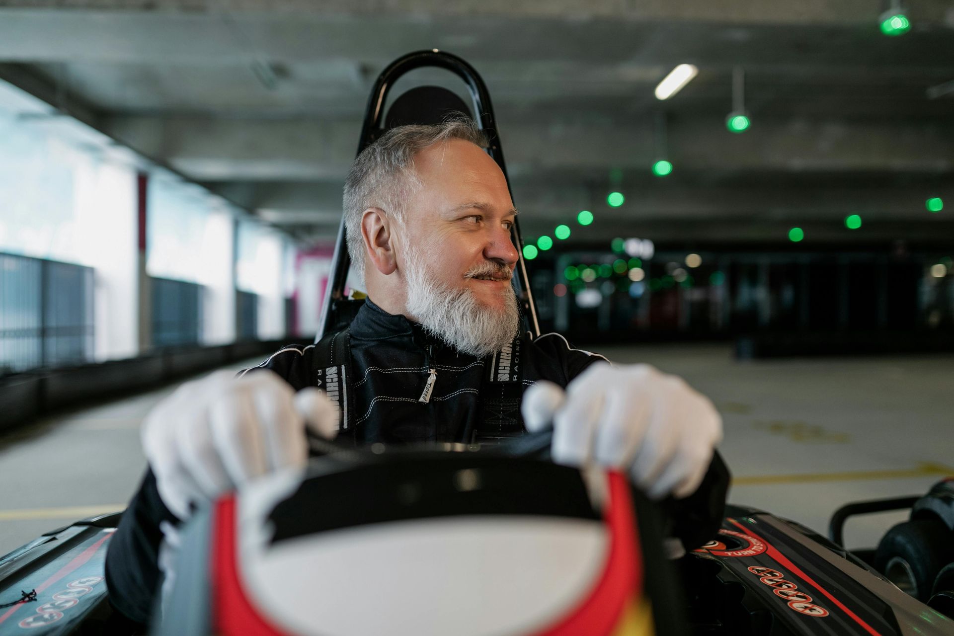Un homme avec une barbe conduit un kart sur une piste.