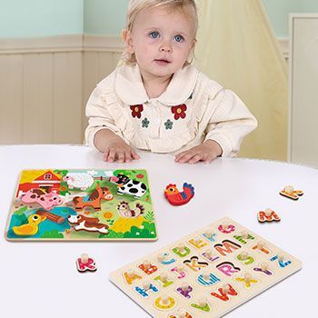 Criança brincando com jogo de encaixe feito de madeira  da tooky toy