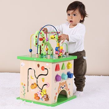 Criança brincando com cubo de atitividades feito de madeira reflorestada da tooky toy