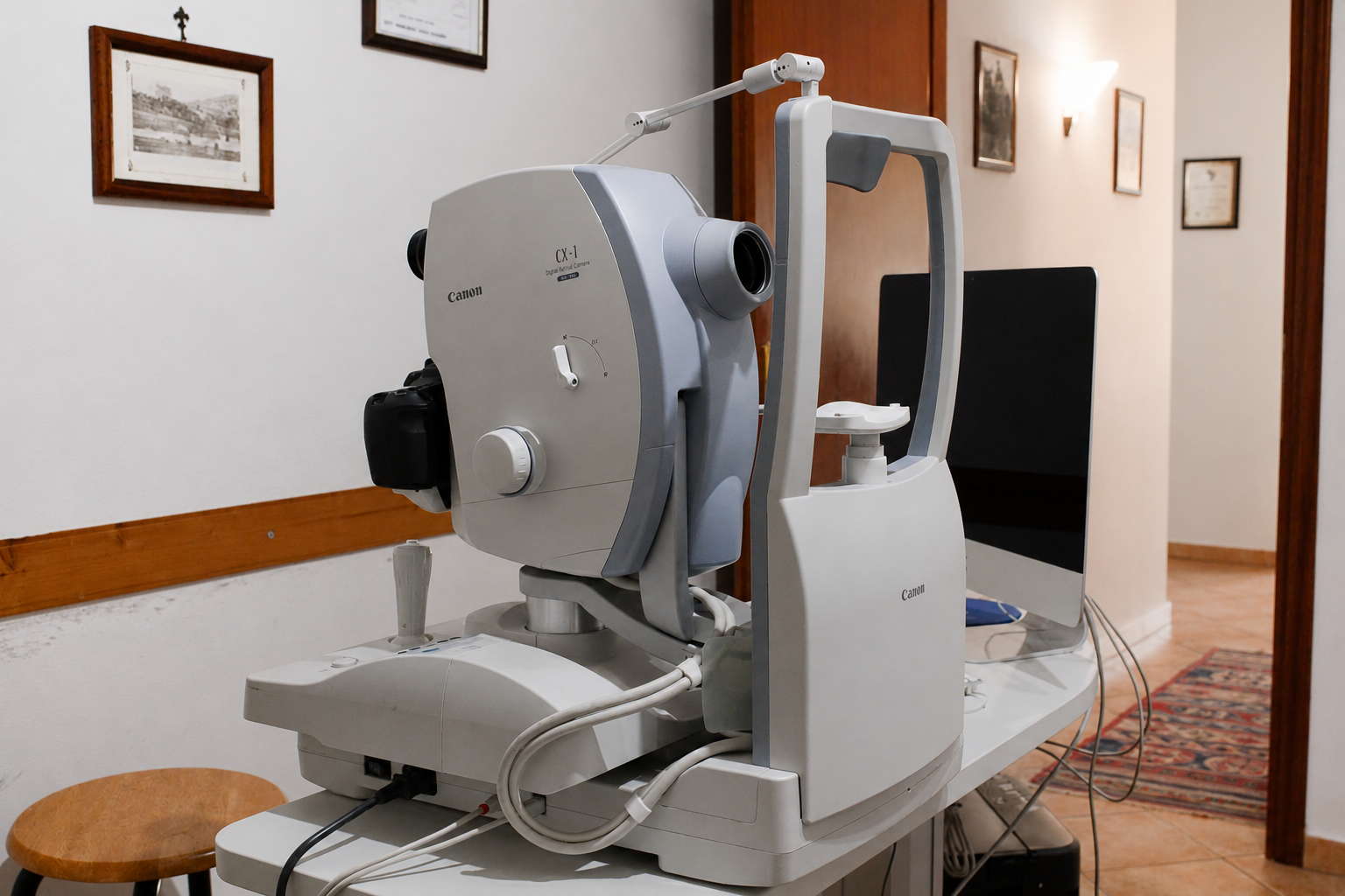 Un grande dispositivo medico ottico in una stanza di una clinica, con quadri incorniciati alle pareti e moquette.