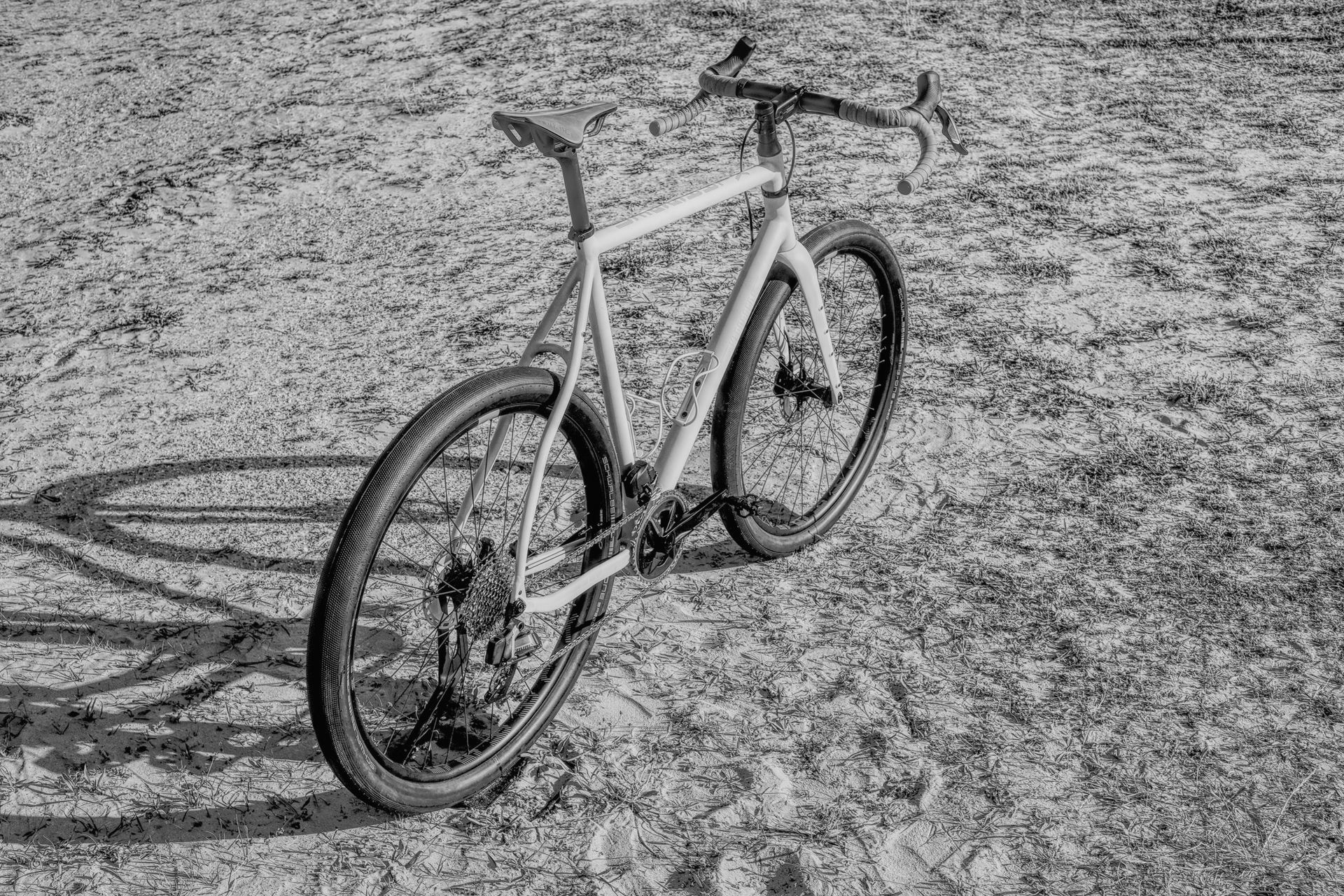 A black and white photo of a Klaassen Multipurpose in Beach Race setup with Tailwind wheels in the sand.