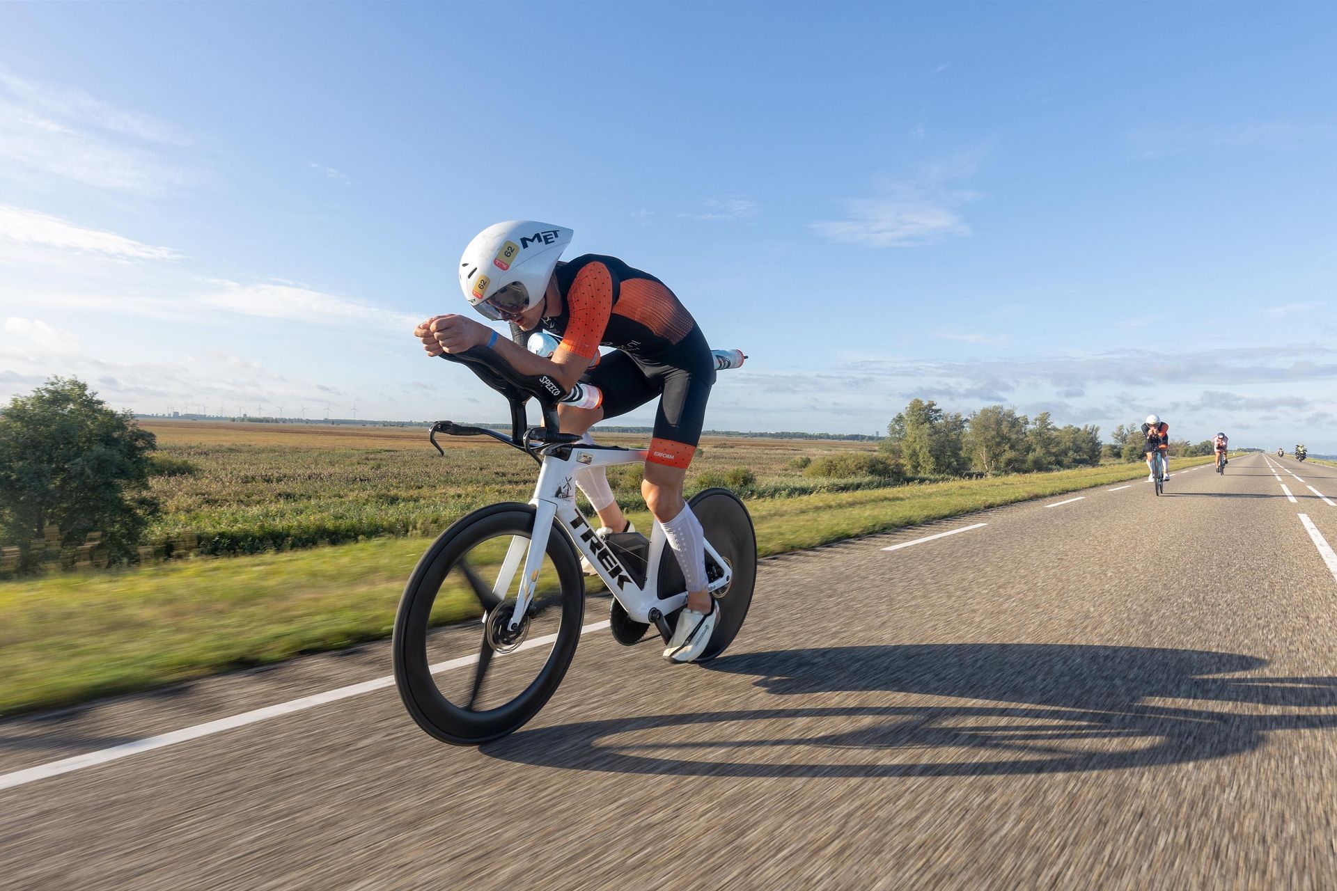 Triathlete crossing finish line, arms raised in victory.