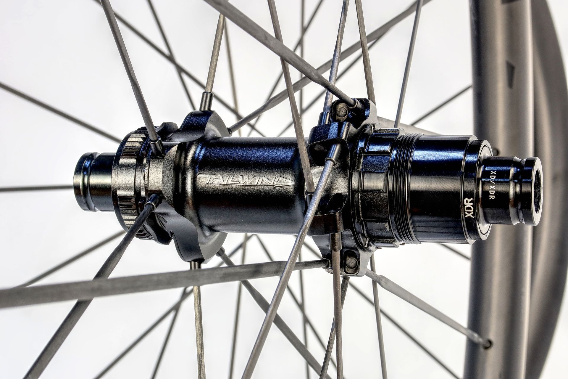 A close up of a carbon road bicycle wheel with subtle logo