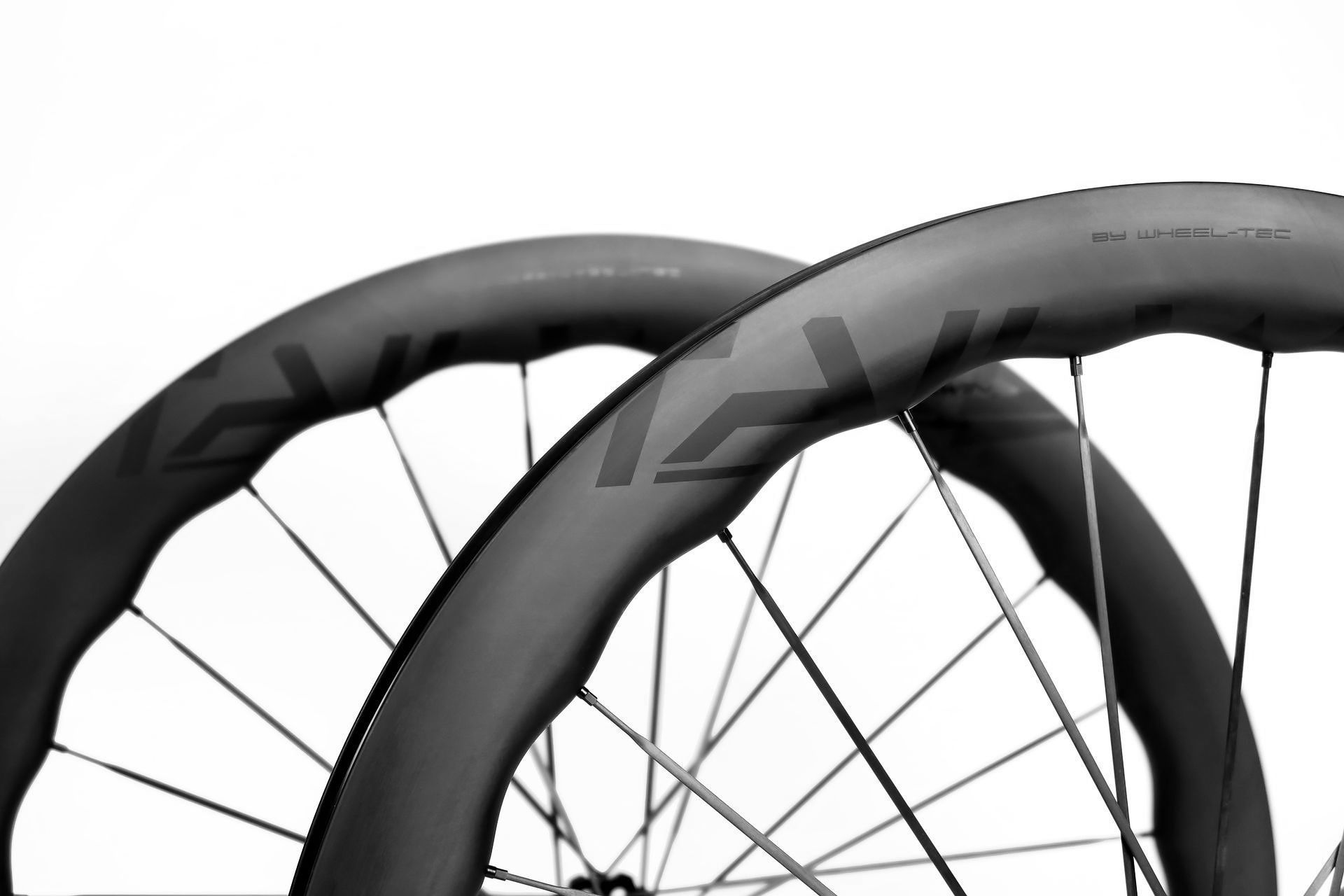 Two tailwind waved carbon fiber bicycle wheels, black and gray, against a white background.
