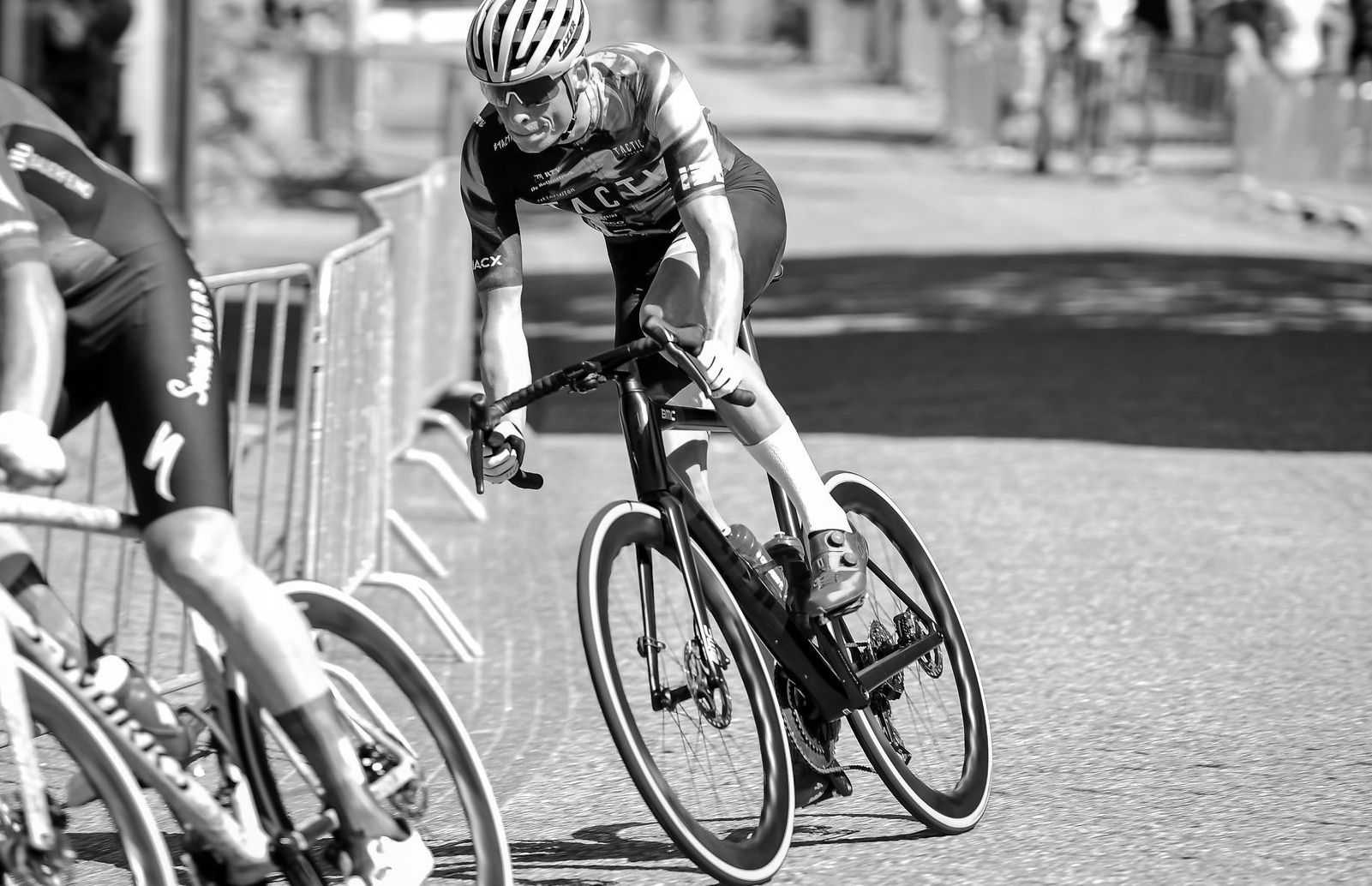 A black and white photo of a person riding a bike with tailwind carbon waved wheels
