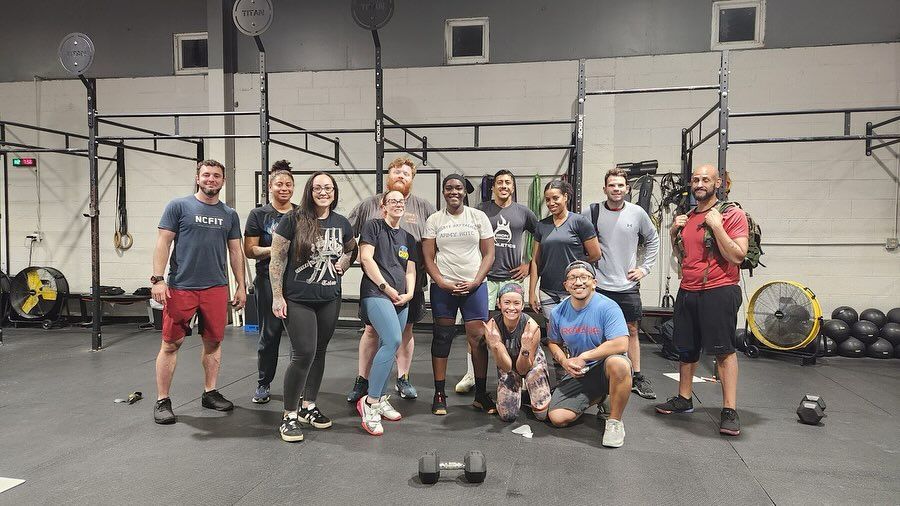 A group of people are posing for a picture in a gym.