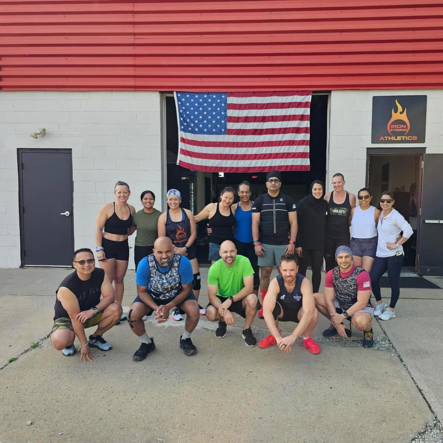 A group of people posing for a picture in front of an american flag