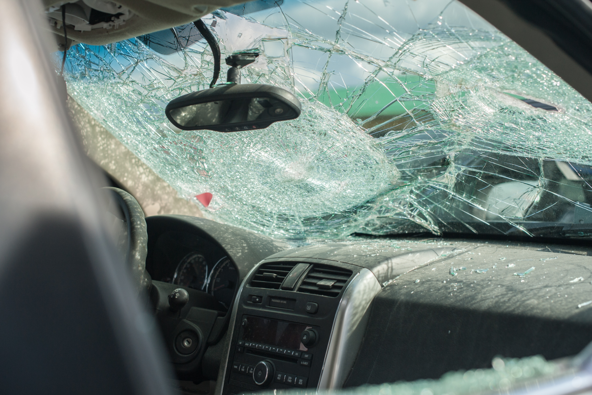 Cracked windshield and shattered dashboard view inside a car after impact