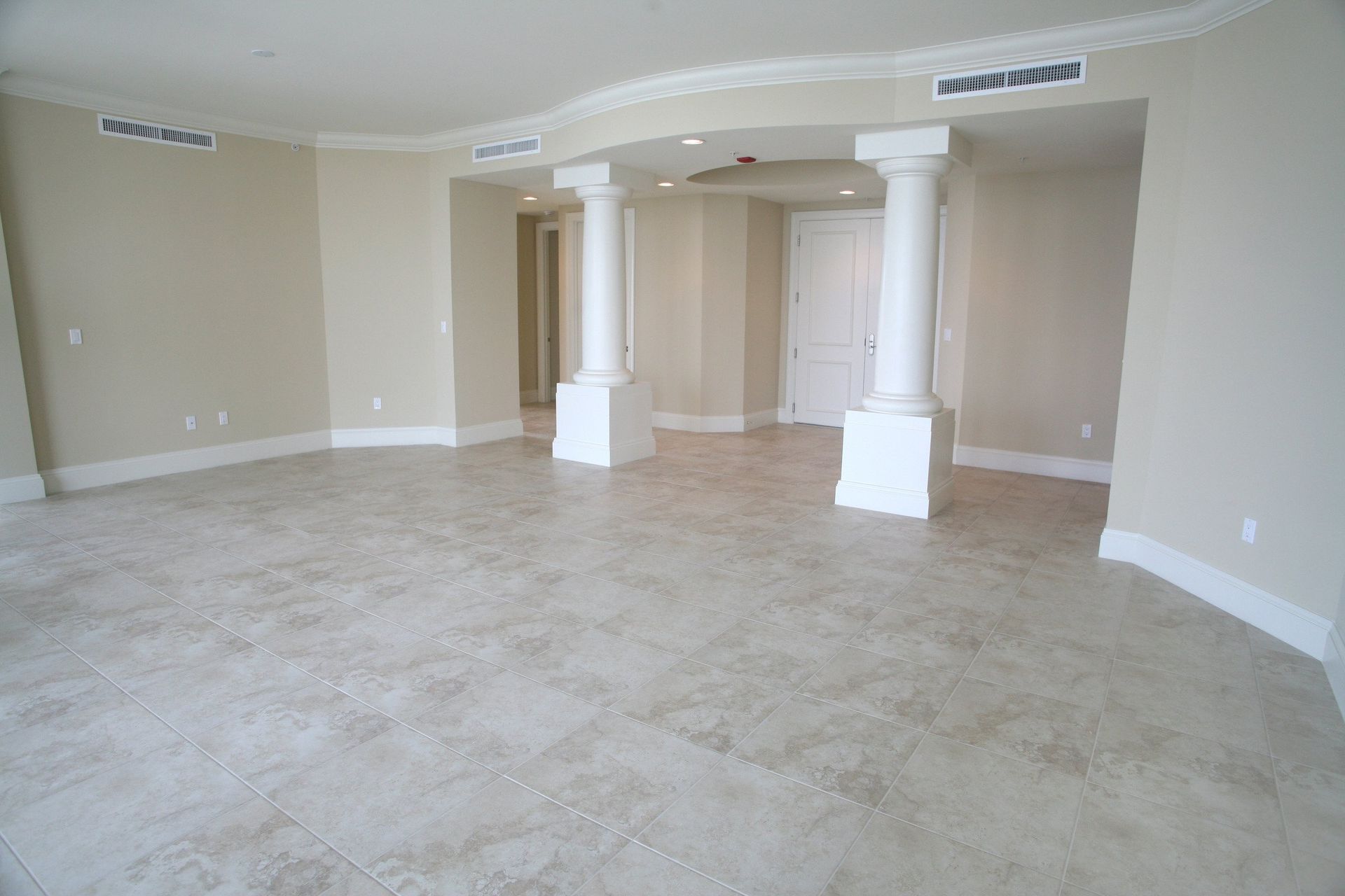 A large empty room with columns and tile floors