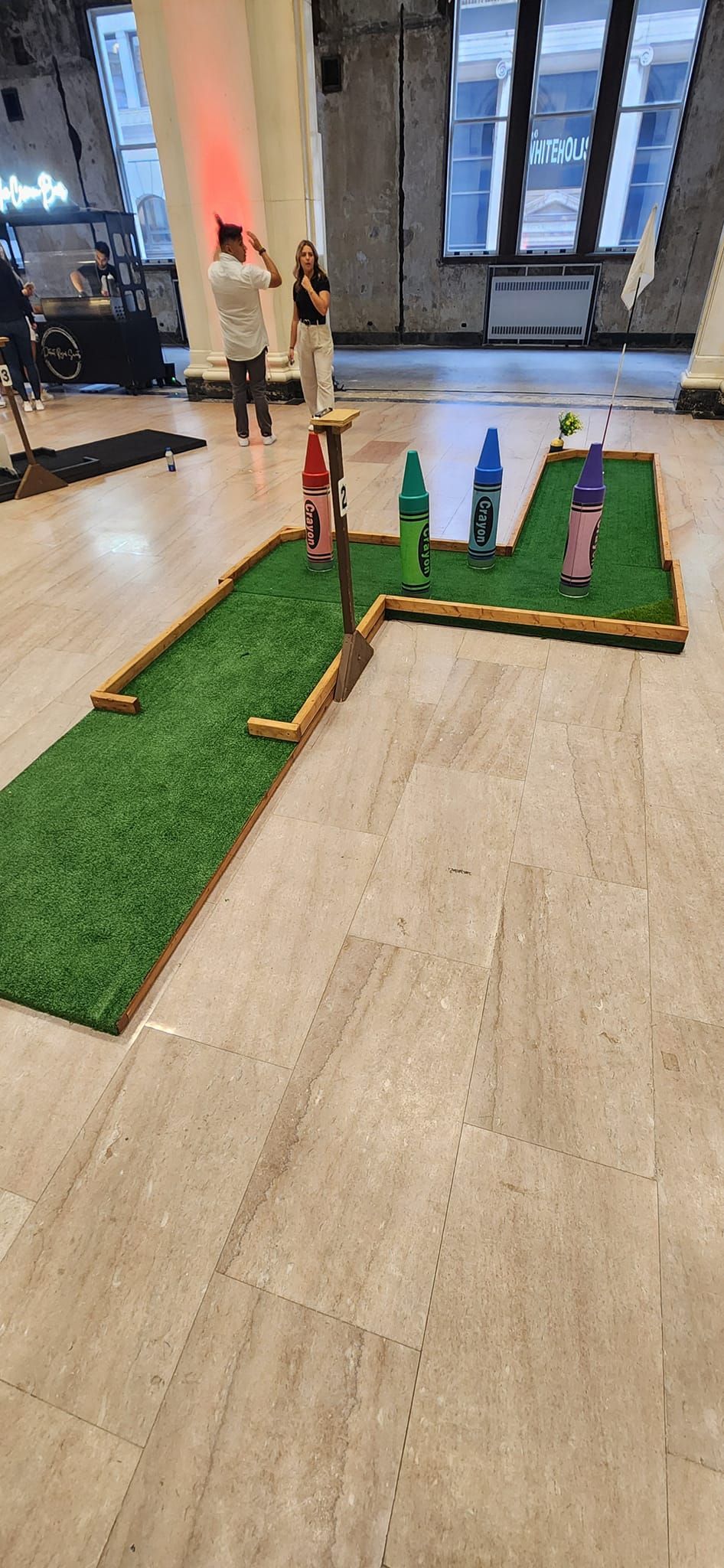 Miniature golf course with a red barn and a cow cutout.