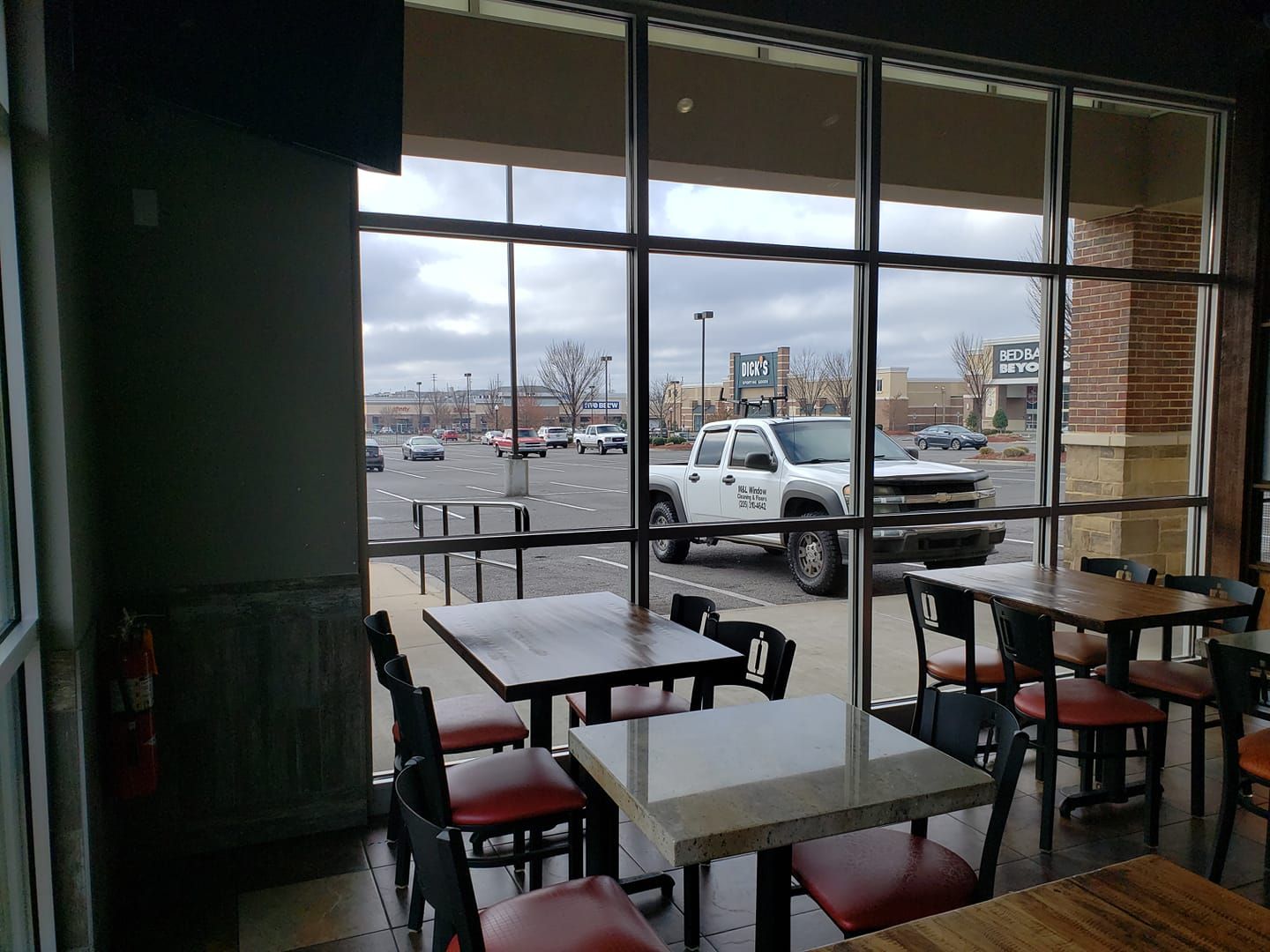 A restaurant with tables and chairs and a truck parked in the parking lot.