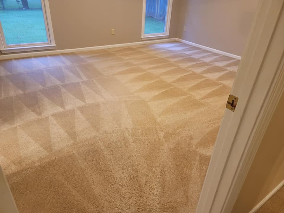 A bedroom with a carpeted floor and two windows.
