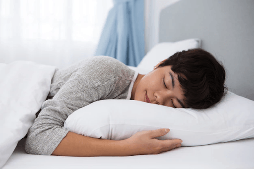 perempuan sedang memeluk bantal empuk