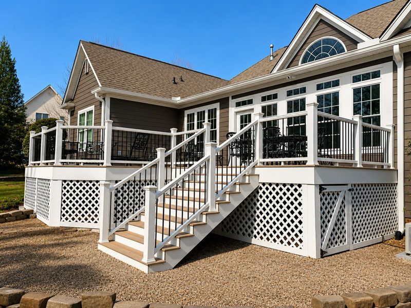 house with raised porch, steps, and lattice skirting under a clear blue sky
