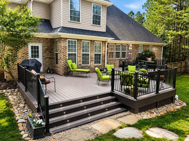 Back deck with black railings, outdoor seating, and steps