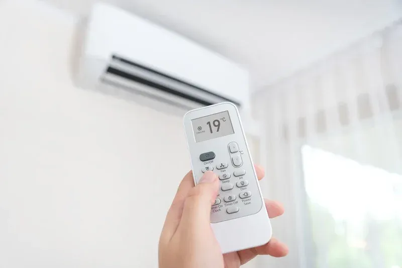Técnico instalando ar condicionado split em sala residencial