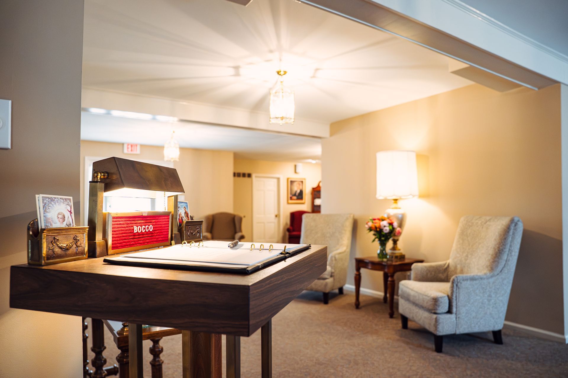 Spacious room with a billiards table, blue armchair, lamp, and framed wall art