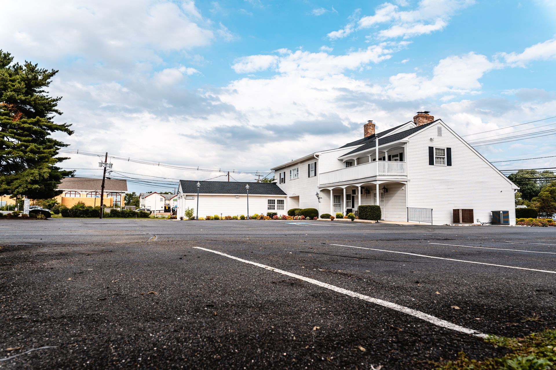 Empty parking lot beside a white building under a blue sky