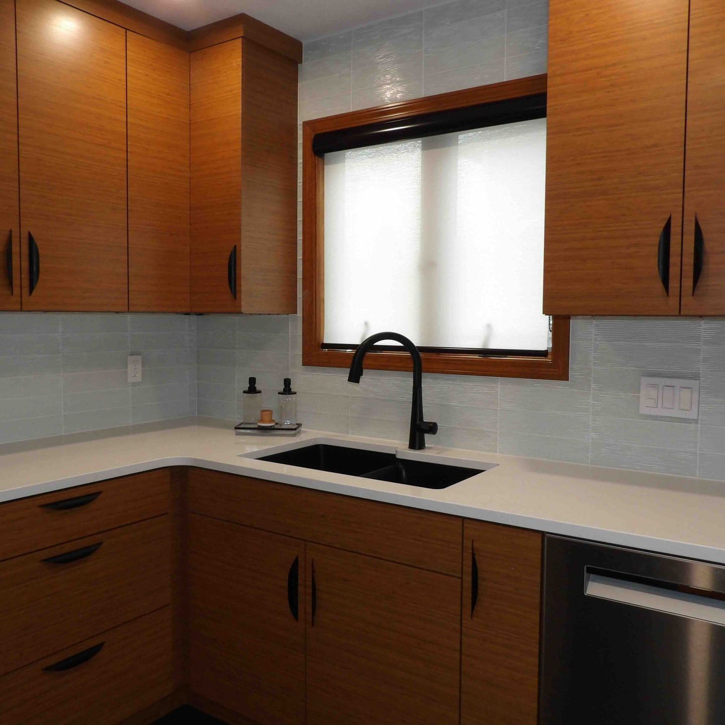 A kitchen with wooden cabinets and a stainless steel dishwasher