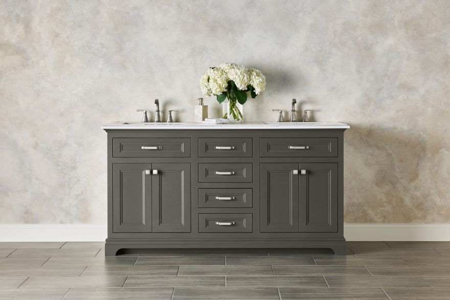 A bathroom vanity with a vase of flowers on top of it.