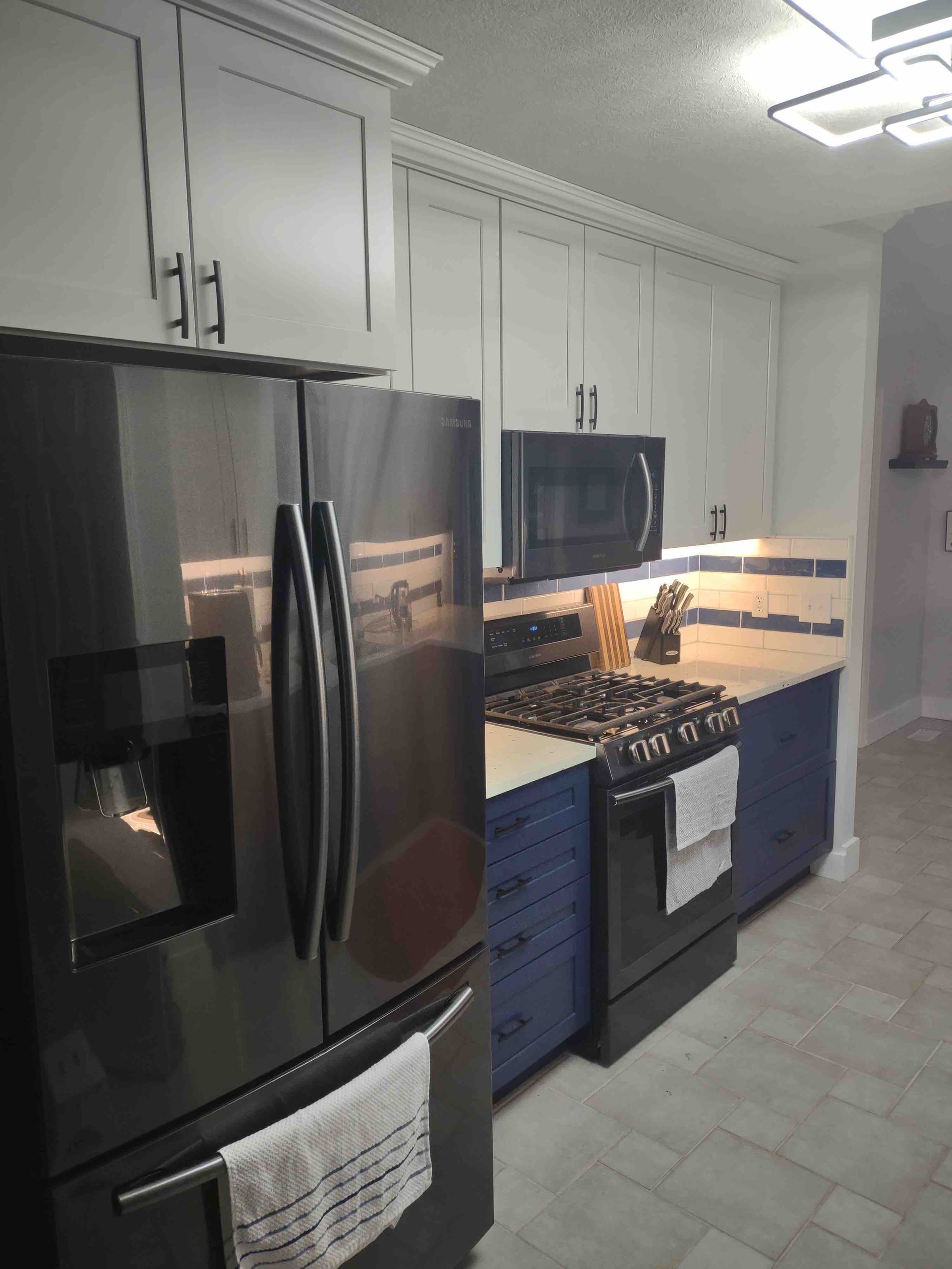 A kitchen with stainless steel appliances and blue cabinets