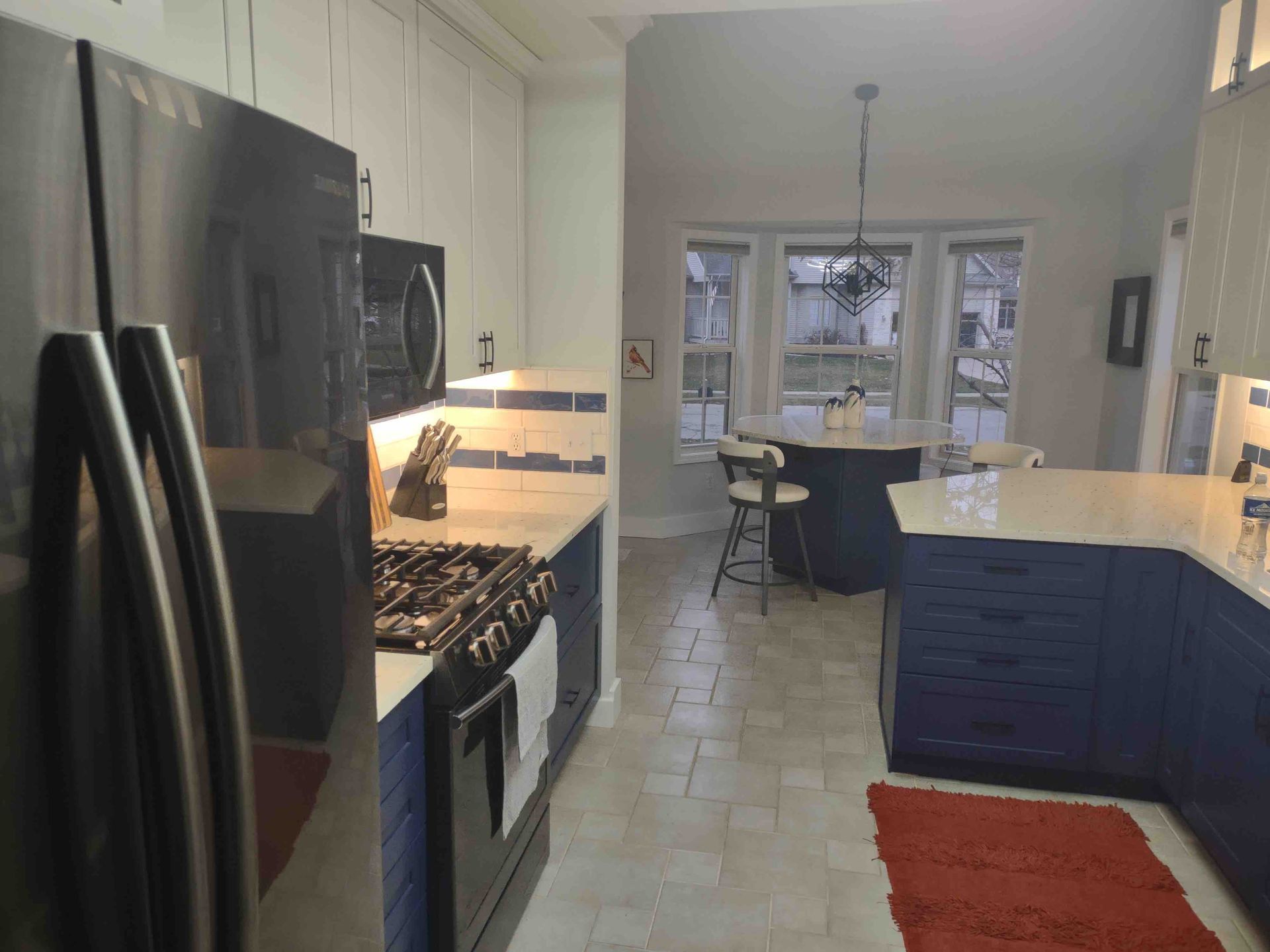 A kitchen with blue cabinets and a black refrigerator