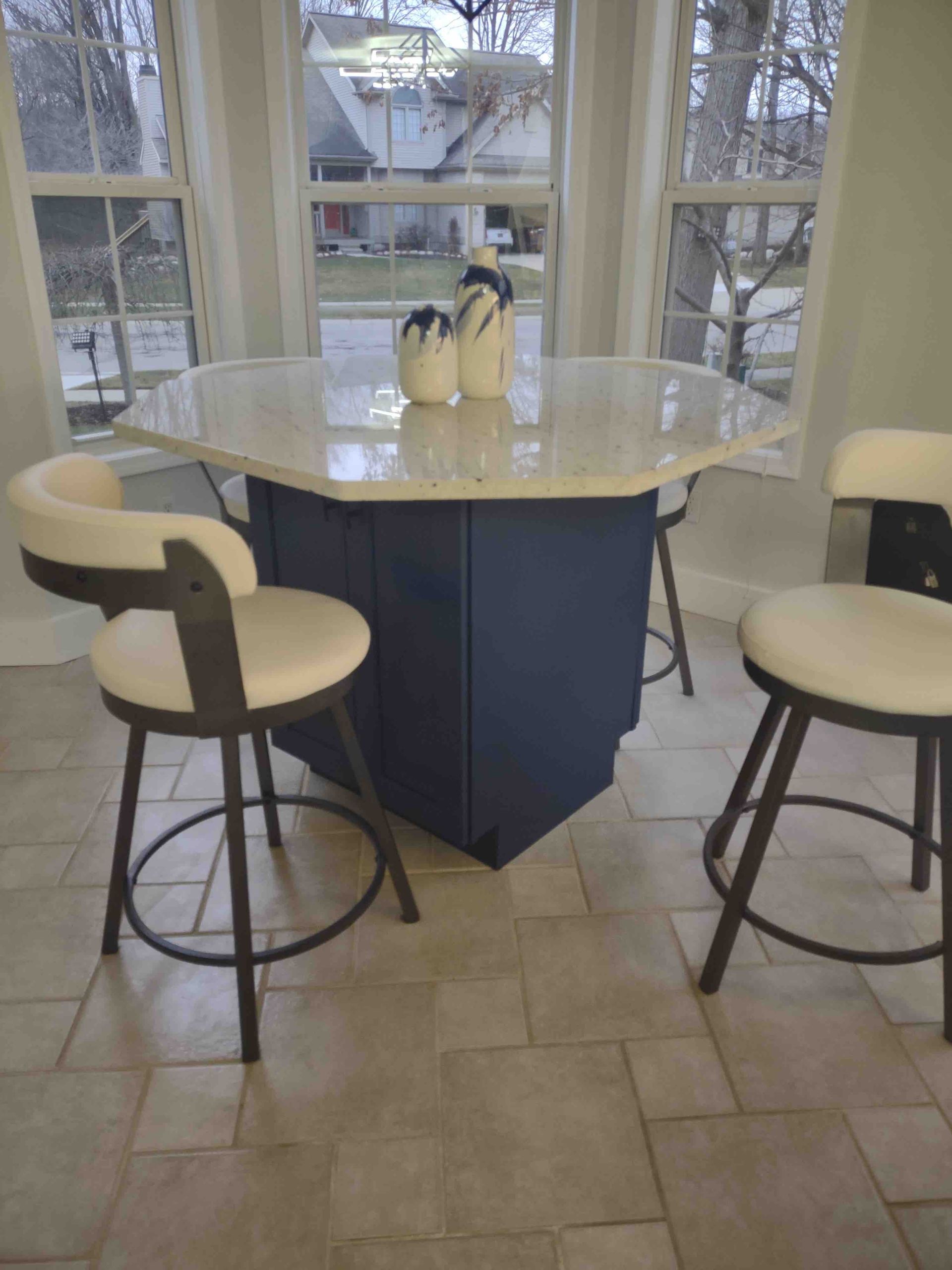 A blue table with white chairs in front of a window