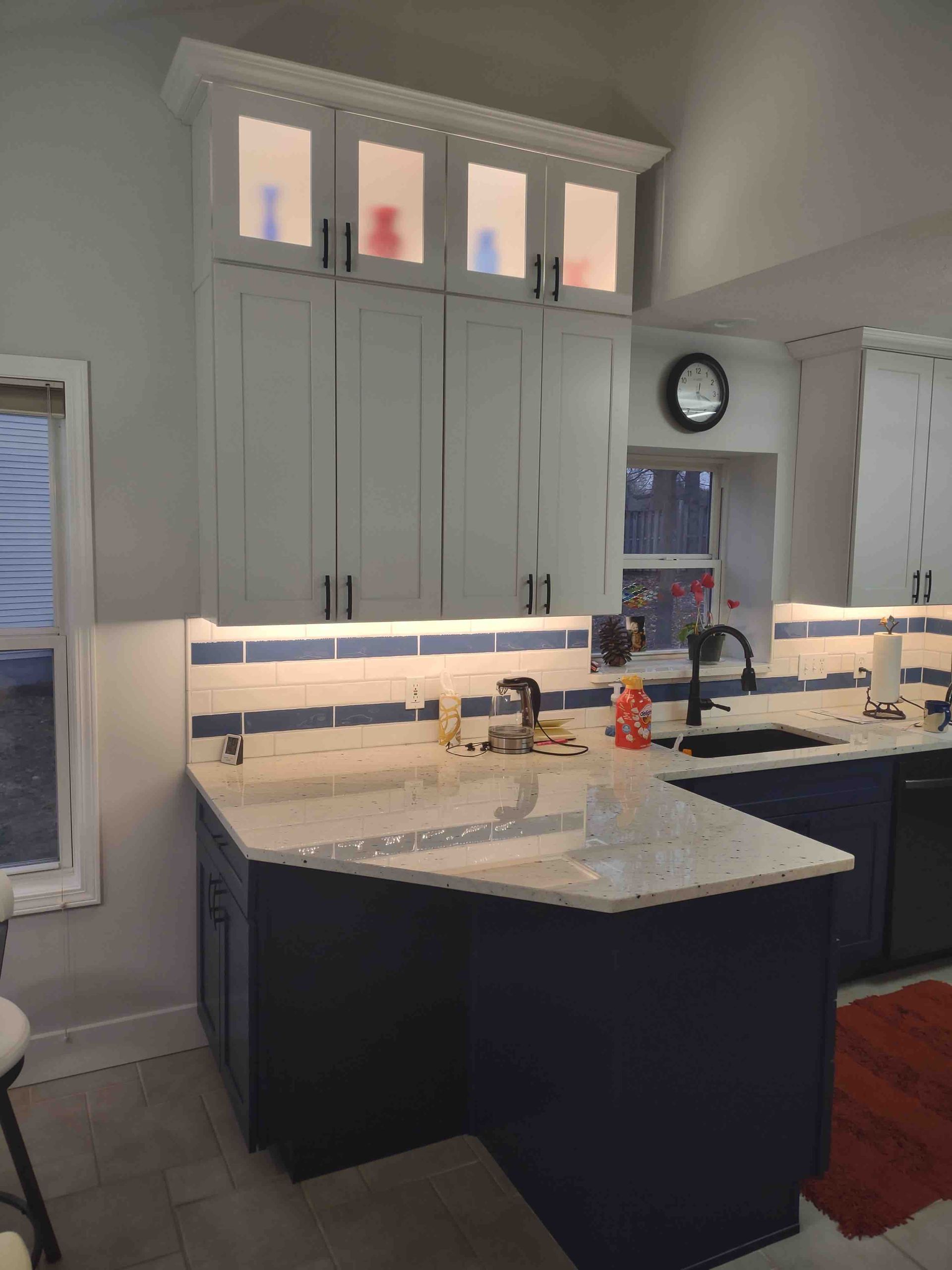 A kitchen with blue cabinets and white counter tops