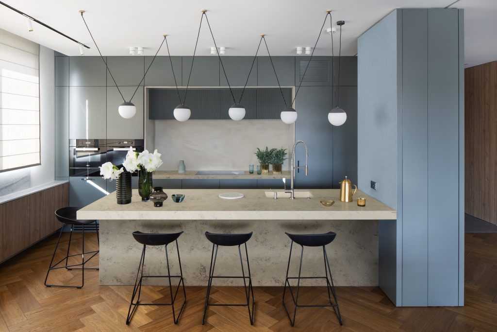 A kitchen with a large island and stools.