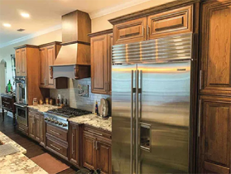 A kitchen with stainless steel appliances and wooden cabinets.