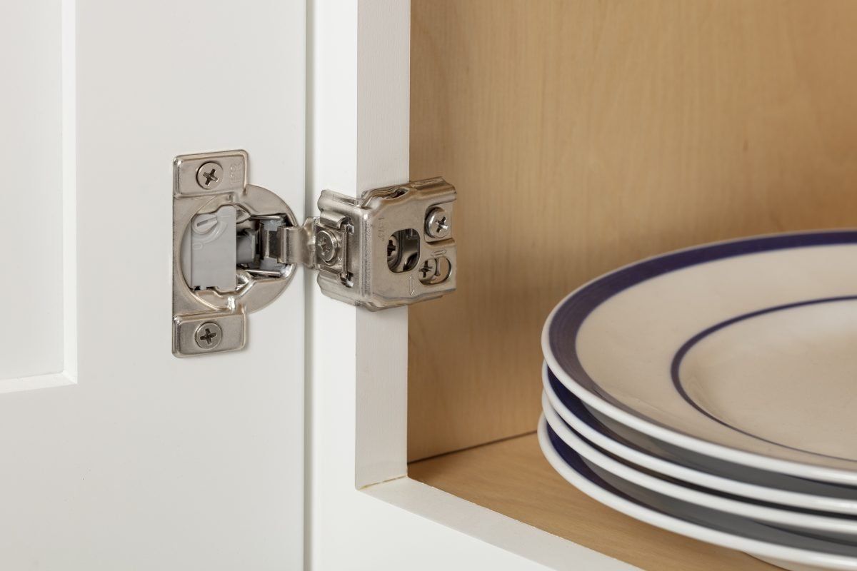 A stack of plates are sitting on a shelf in a cabinet.